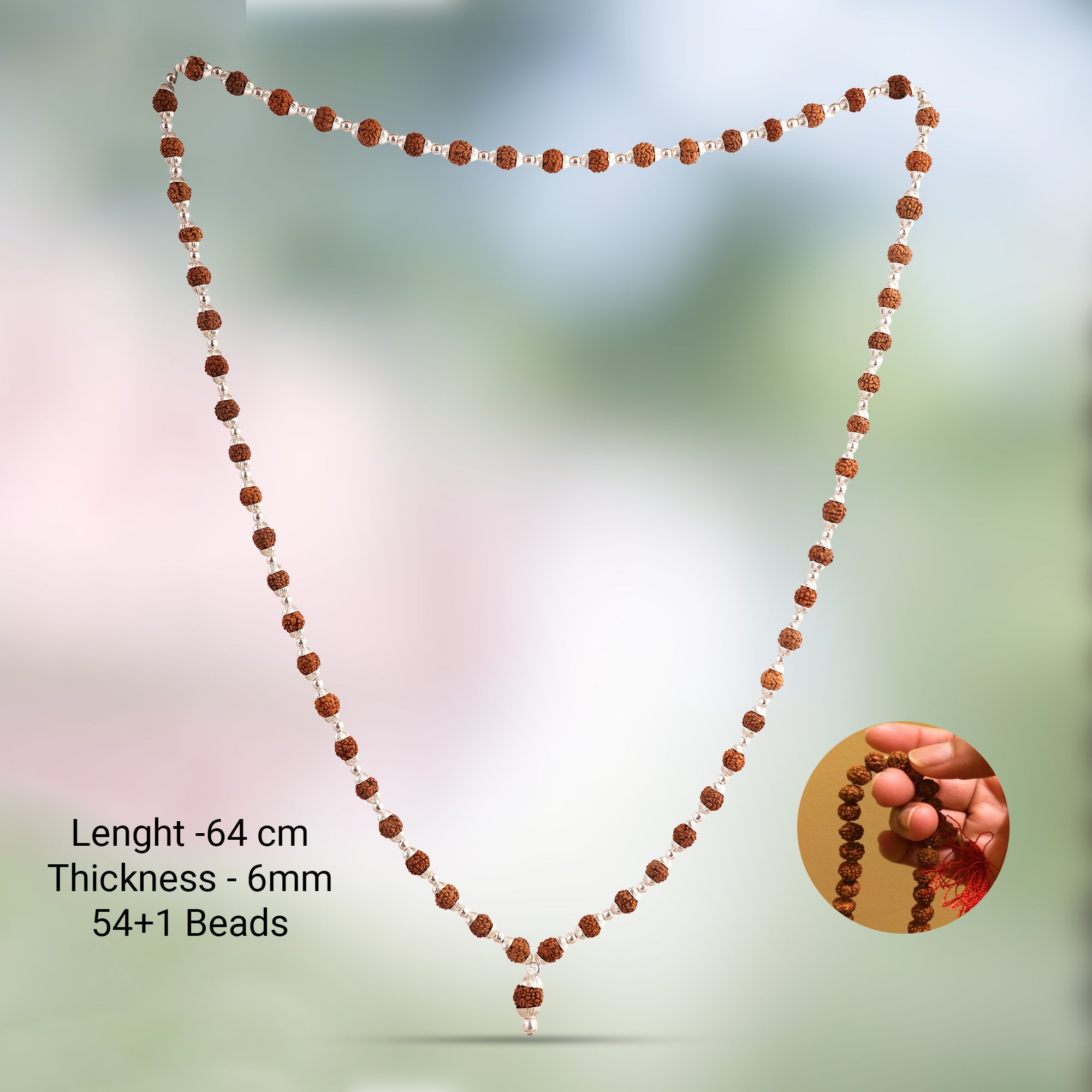 A beaded necklace made of brown and white beads, displayed on a soft blurred green background. Text on the left reads 'Lenght - 64 cm, Thickness - 6mm, 54+1 Beads', and a circular inset on the bottom right shows a hand holding the necklace.